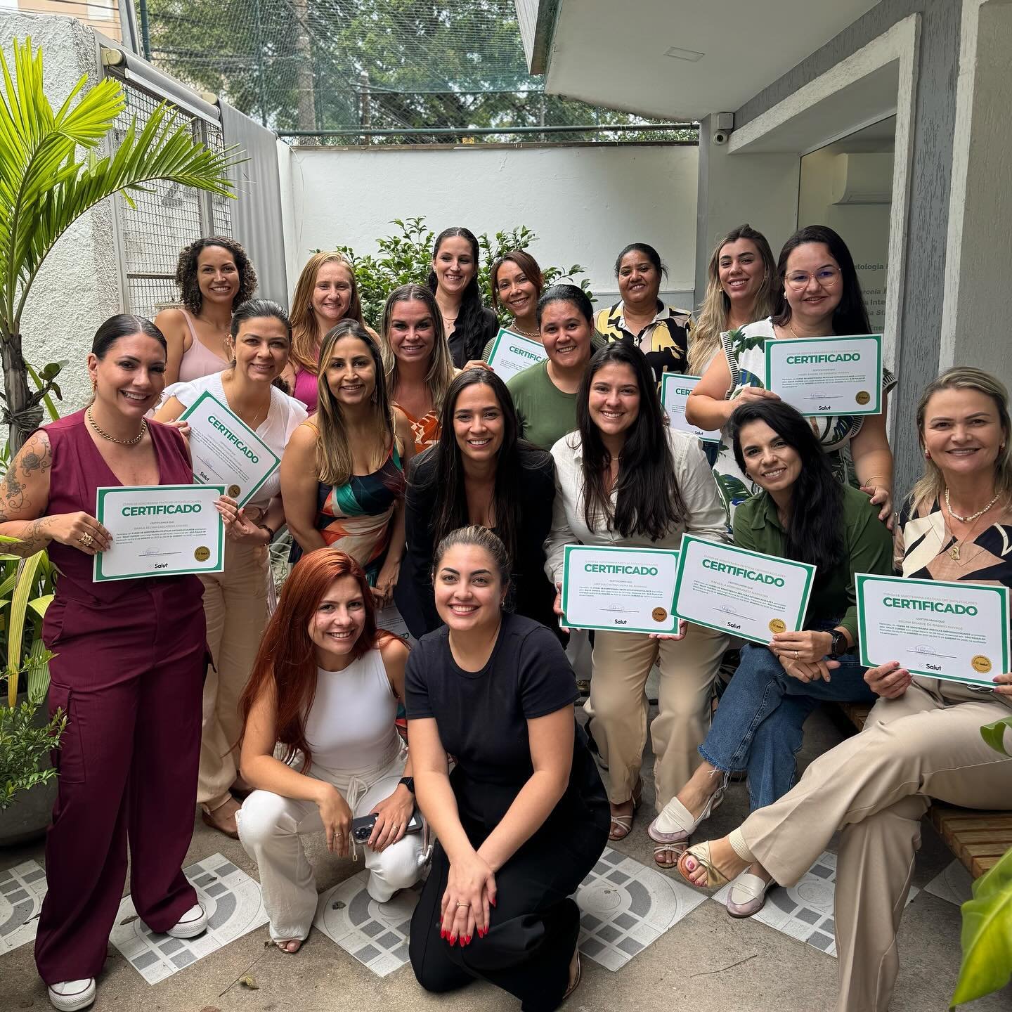 Turma com certificados no jardim da unidade da Salut